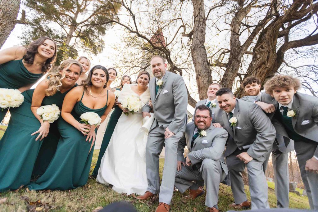 A group of bridesmaids and groomsmen posing for a wedding portrait.