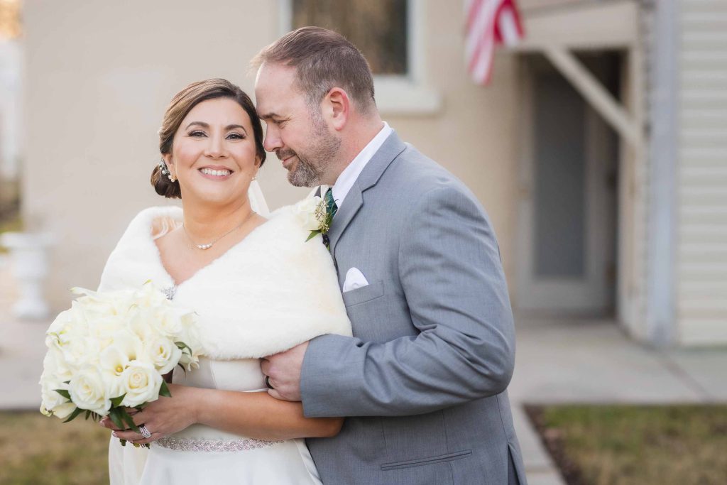 A portrait of a bride and groom embracing on their wedding day.