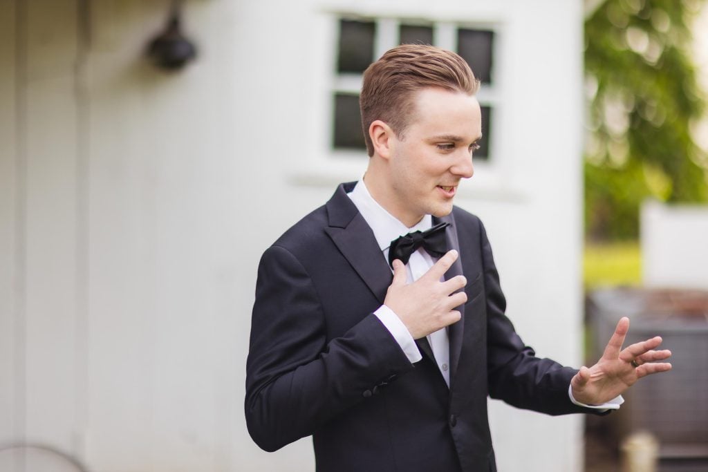 A man in a tuxedo is posing for a portrait.
