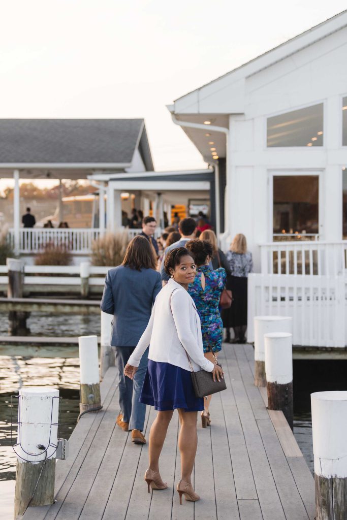 A wedding party walking down a dock.