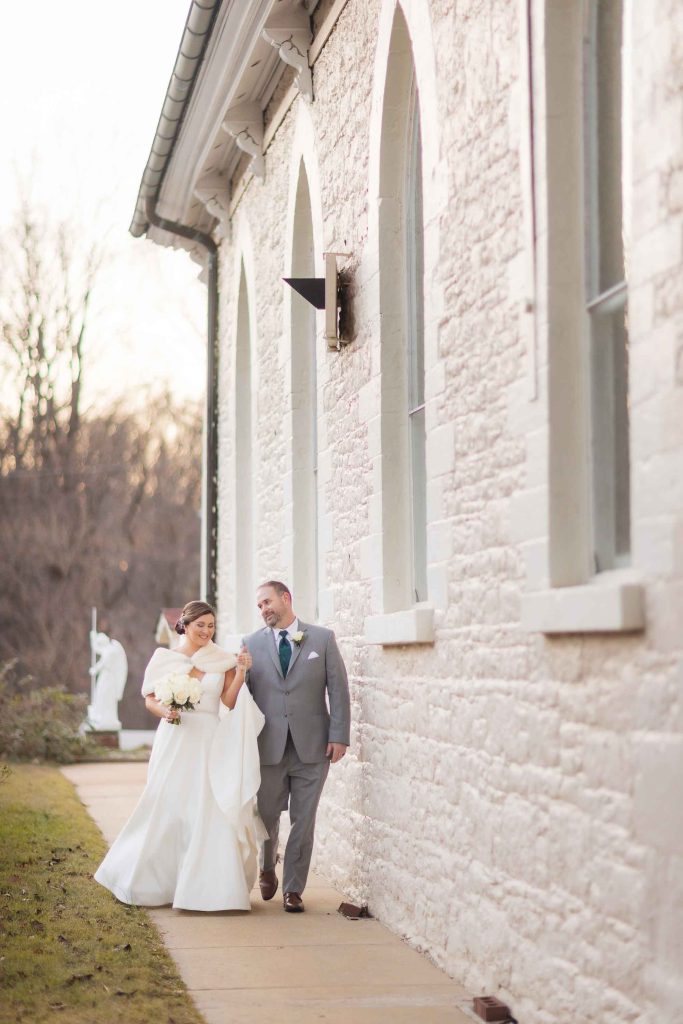A wedding portrait of a bride and groom in front of a building.