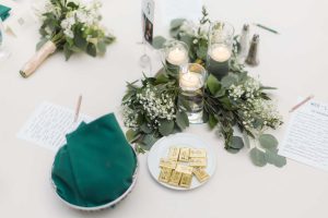 A detailed wedding table adorned with greenery and candles.