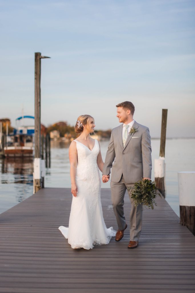 A wedding portrait featuring a bride and groom on a dock.