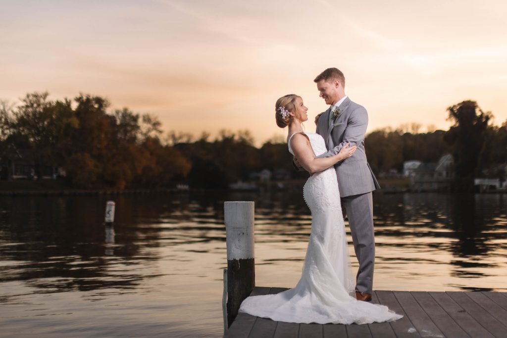 A wedding portrait on a dock at sunset.