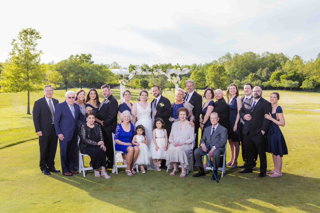 A group of people posing for a portrait on a golf course.