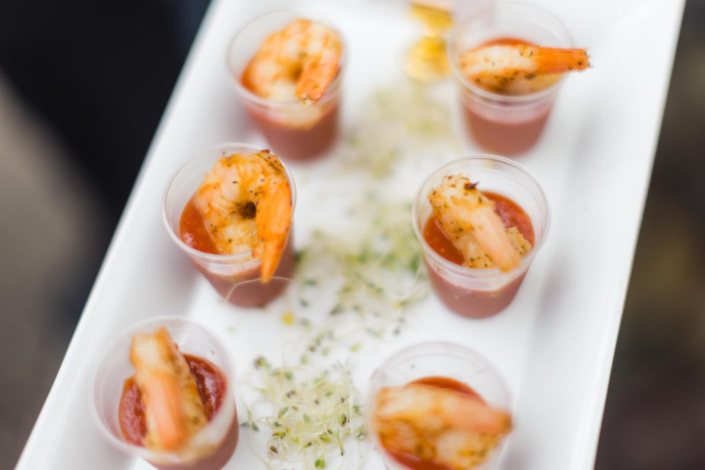 A white plate with shrimp and sauce on it, showcasing intricate details.