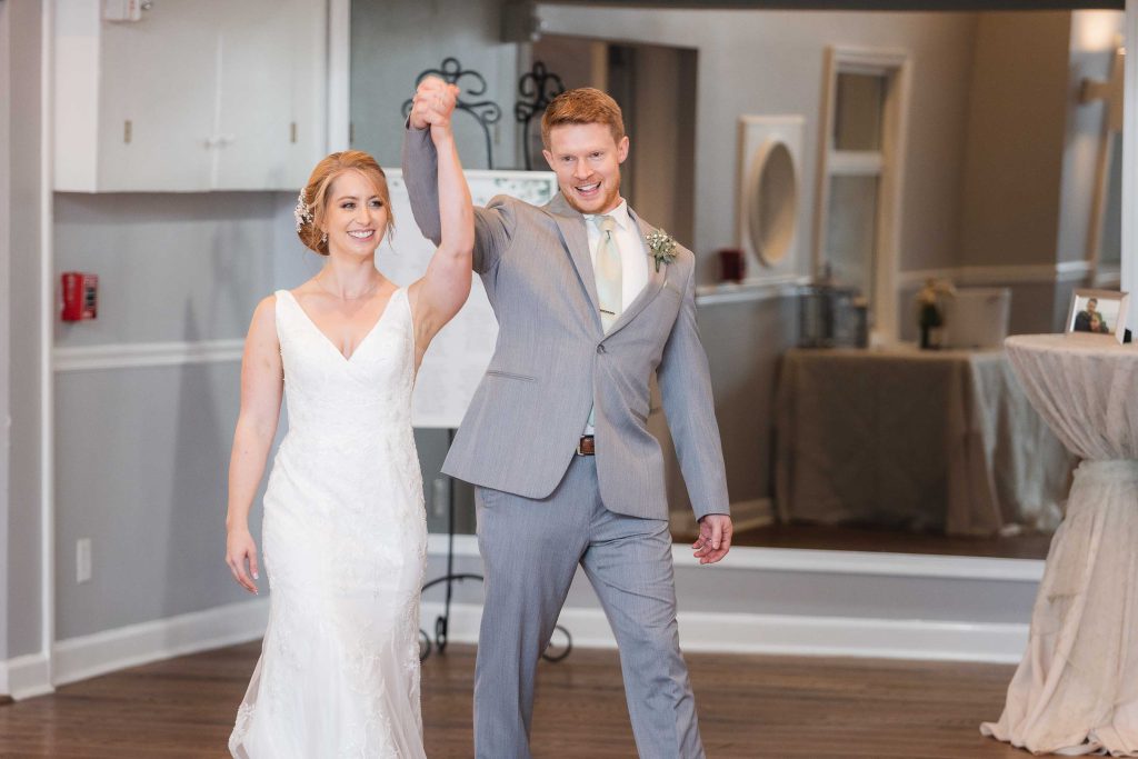 A bride and groom walking down the aisle at their wedding reception.
