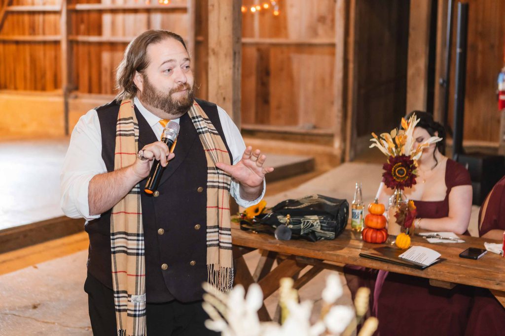 A man speaking into a microphone at a wedding reception.