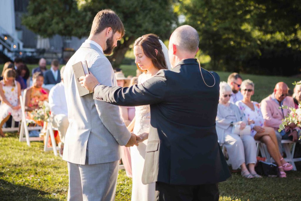 A couple exchanging their vows at an outdoor wedding ceremony.