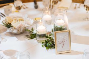 A wedding table with candles and greenery as details.