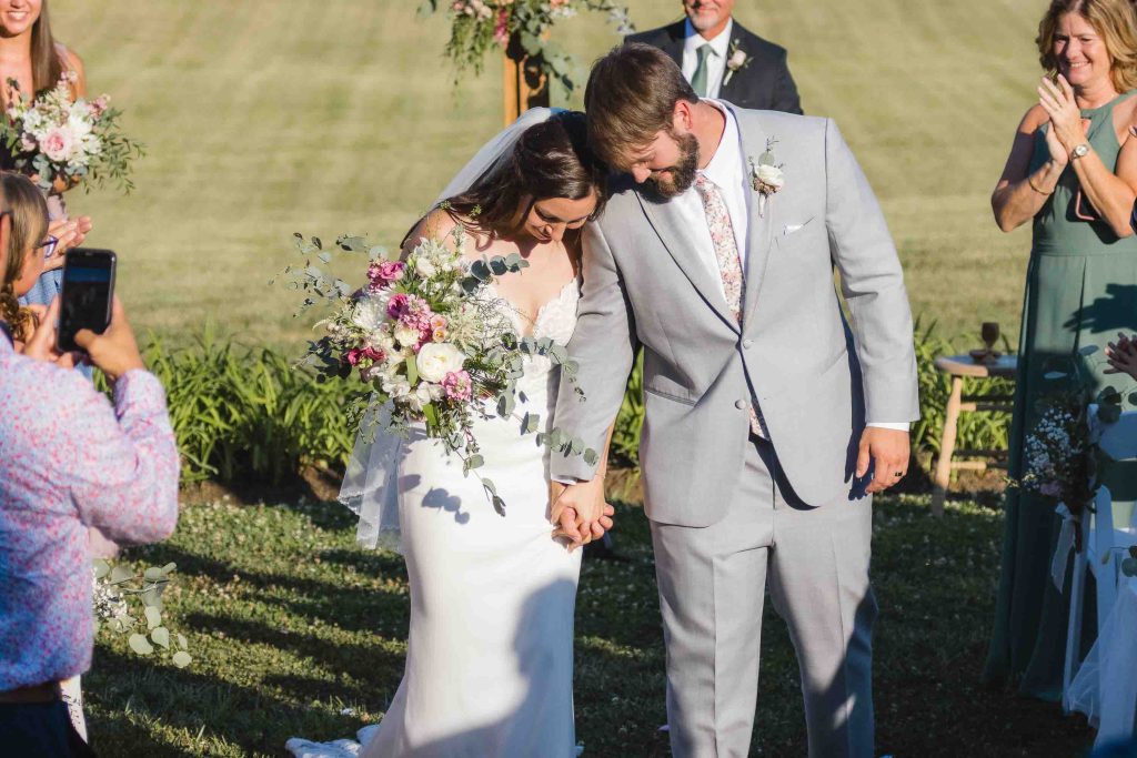 A bride and groom have a ceremony at their outdoor wedding.