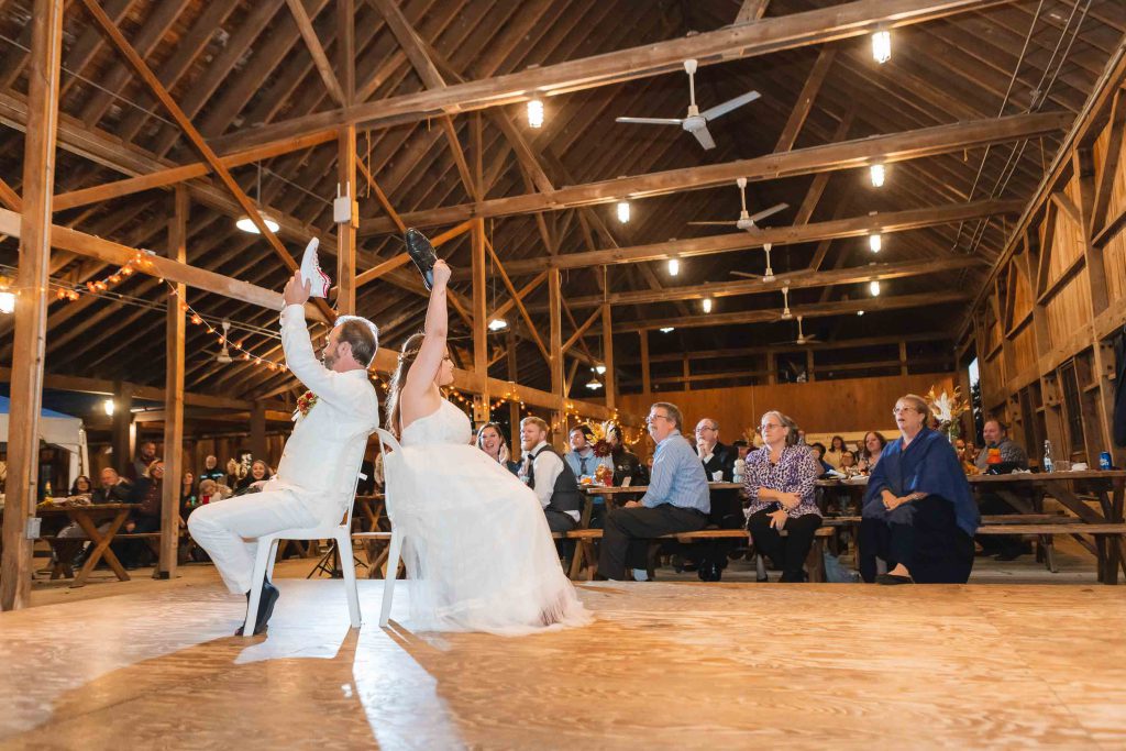 A bride and groom dancing at their wedding reception in a barn.