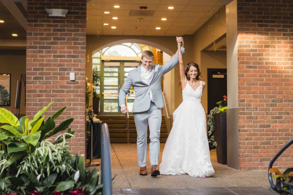 A bride and groom are exiting a wedding reception.