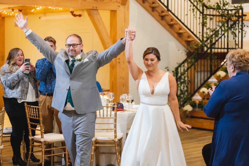 A couple is walking down the aisle at their wedding reception.