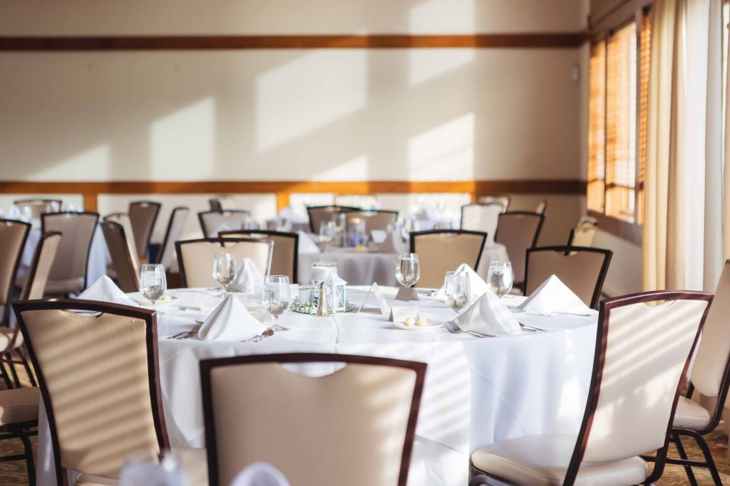 Details: A room with detailed tables and chairs set up for a wedding reception.