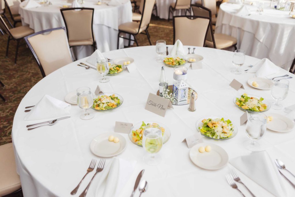 A detailed wedding table setting with plates and silverware.
