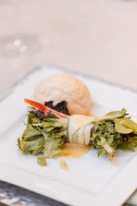 A white plate with a piece of food on it, showcasing wedding details.