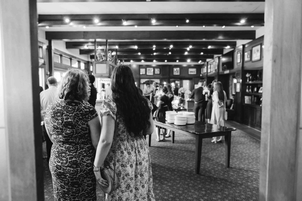 A black and white photo of a group of people at a reception.