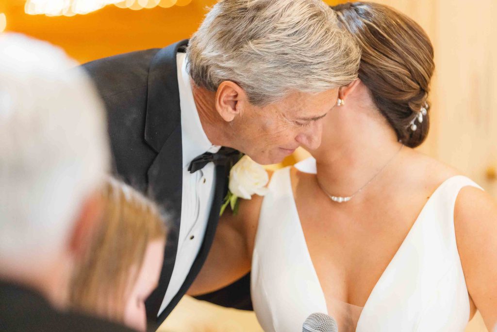 A couple sharing a kiss at their wedding reception.