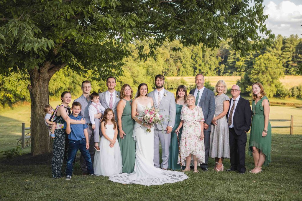 A wedding portrait featuring the happy couple in front of a tree.