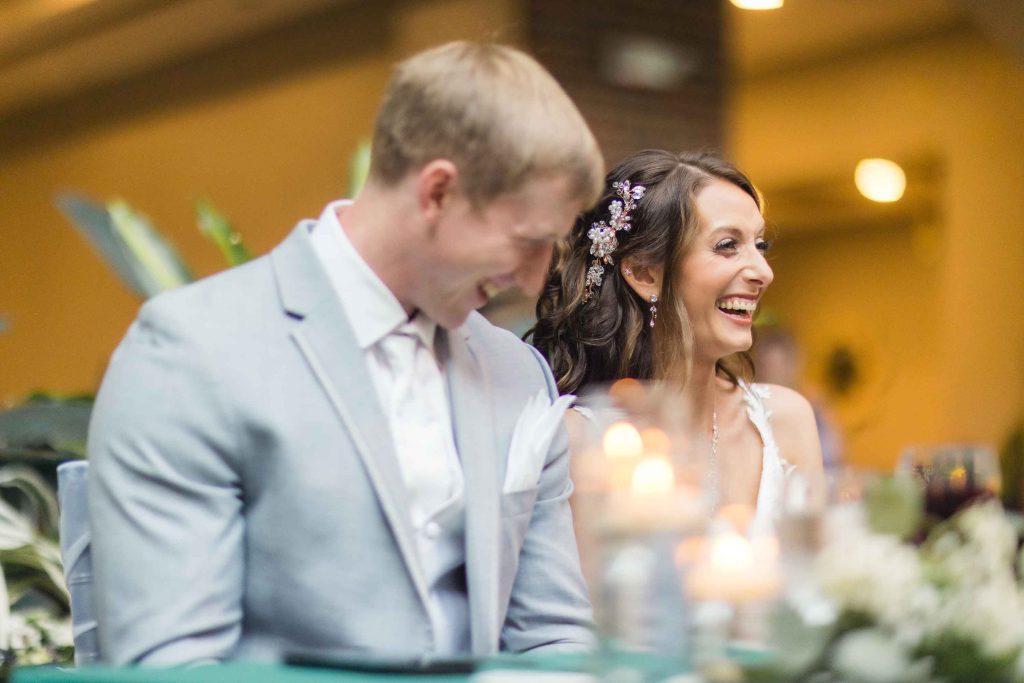 A couple laughing at their wedding reception.