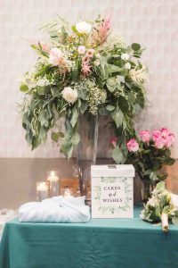 A wedding table with flowers and a sign on it.