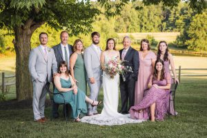 A wedding party posing for a portrait in a field.