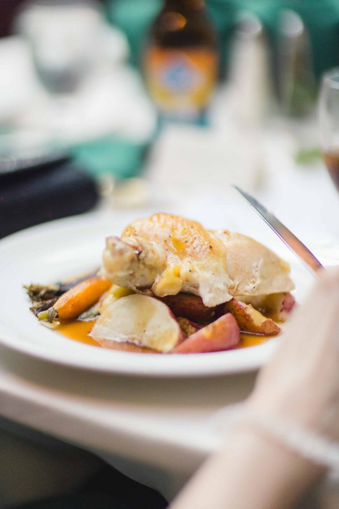 A person is eating a plate of food with wedding details.