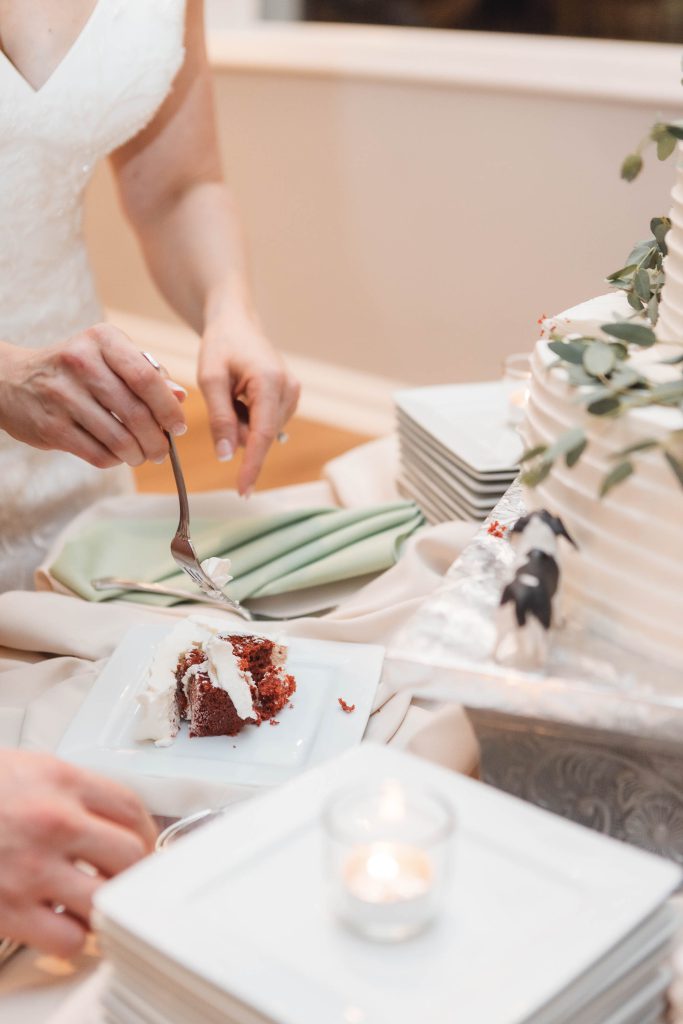 A couple cutting into their wedding cake at their reception.