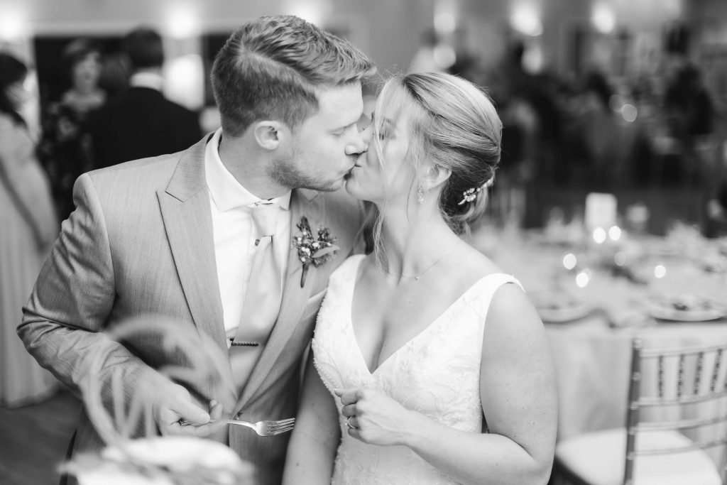 A bride and groom sharing a kiss at their wedding reception.