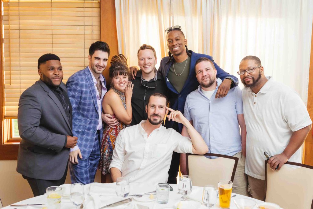 A group of people posing for a picture at a wedding reception.
