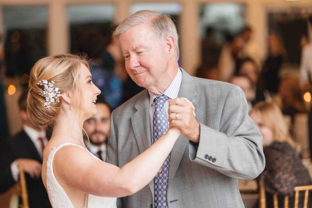 A father and daughter dance at a wedding reception.