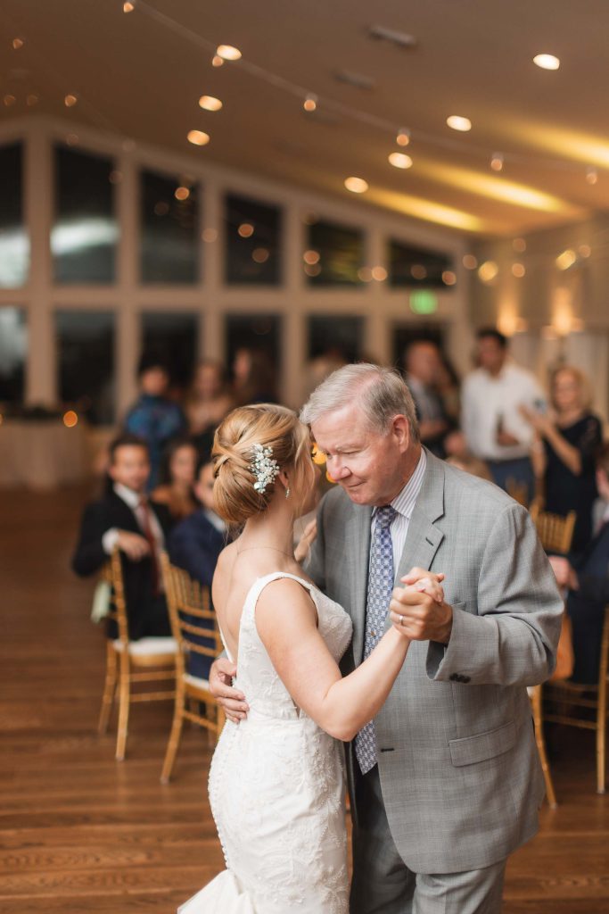 A bride and her father dance at their wedding reception.