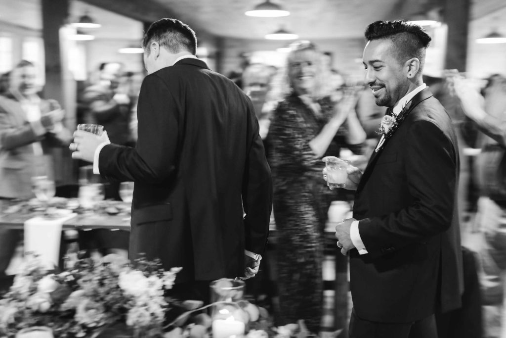 Black and white photo of groom and groomsmen at a wedding reception.