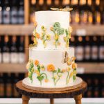 A birthday cake decorated with sunflowers and butterflies.