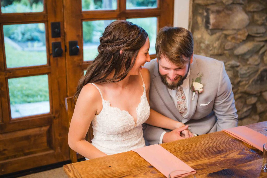 A couple sitting at a table during their wedding reception.