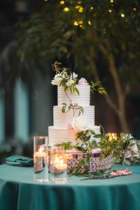 A detailed wedding cake sits on a table.