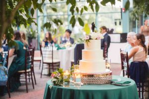A wedding cake sits on a table in a room.