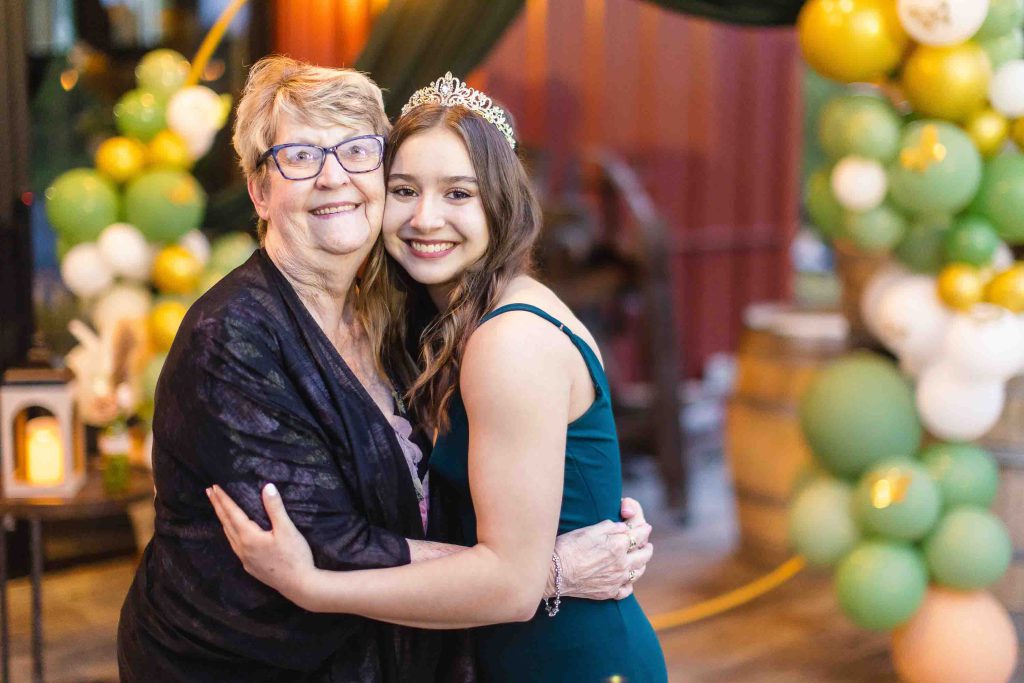 A mother and daughter hugging at a quinceañera birthday party.