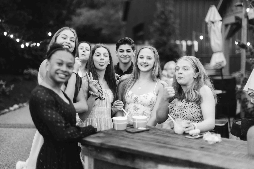 Black and white photo of a group of girls at a bar celebrating a quinceañera.