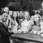 Black and white photo of a group of girls at a bar celebrating a quinceañera.