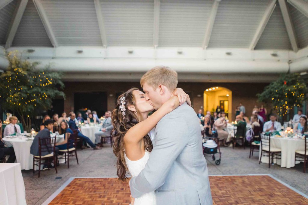 A couple kissing on the dance floor at their wedding reception.