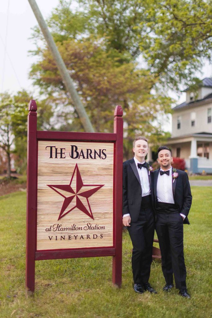 A wedding portrait taken in front of the barns sign.