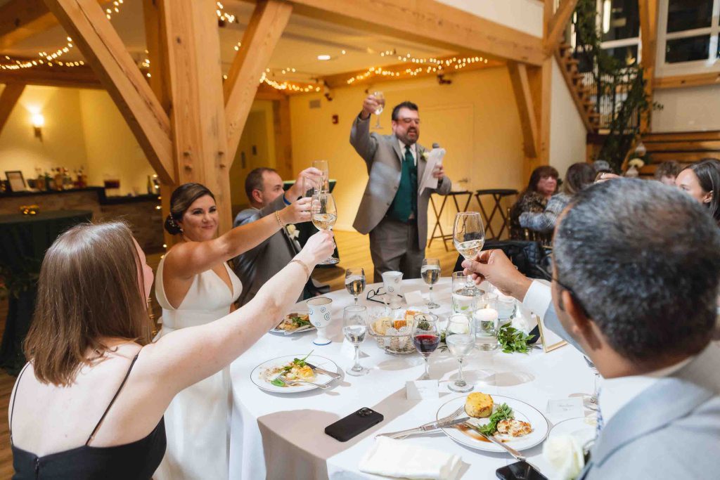 A wedding reception featuring a toasting bride and groom.