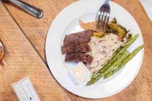 A plate with steak, asparagus, and mashed potatoes for a wedding feast.