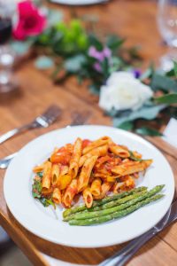 A wedding table with pasta and asparagus.