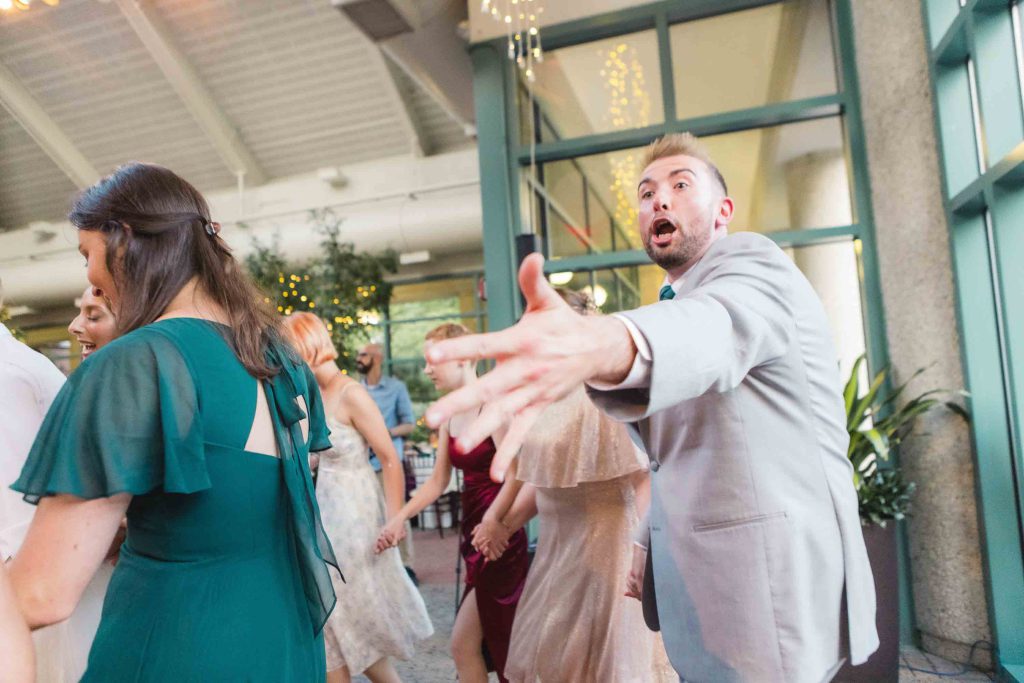 A wedding reception featuring a lively group of people dancing.
