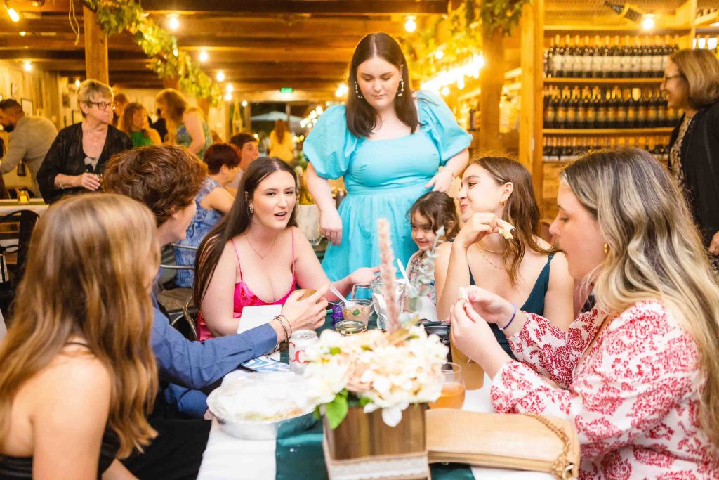 A group of people celebrating a quinceañera at a restaurant.