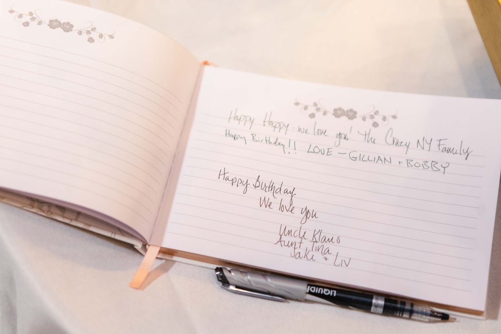 A birthday party guest book with a pen on it.