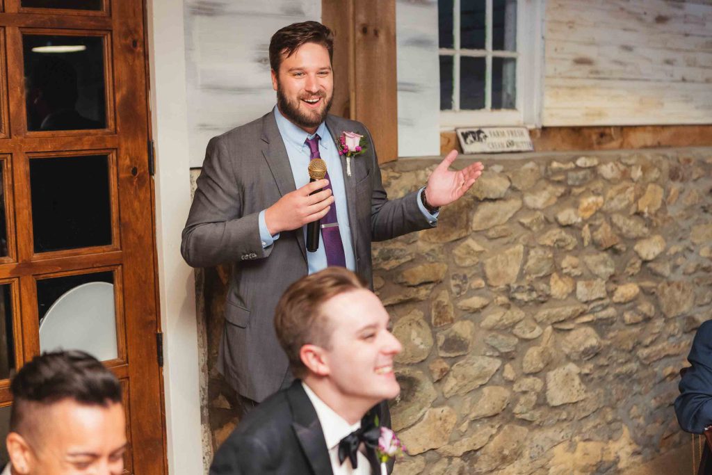 A groom delivering a speech at a wedding reception.